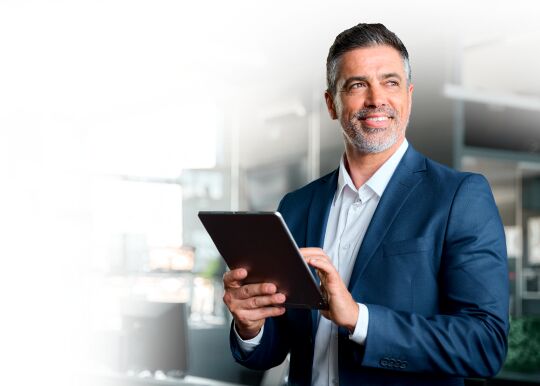 Dirigeant utilisant une tablette dans un bureau lumineux