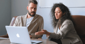 Woman and man looking at a laptop and discussing something