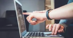 People are pointing at a laptop