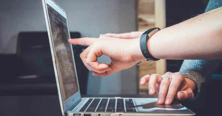 People are pointing at a laptop