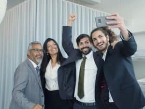 A group of happy looking colleagues making a selfie with each other