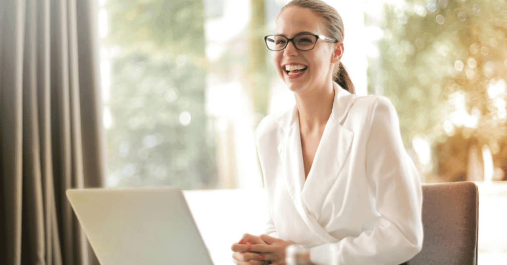 A woman sitting at a desk laughing