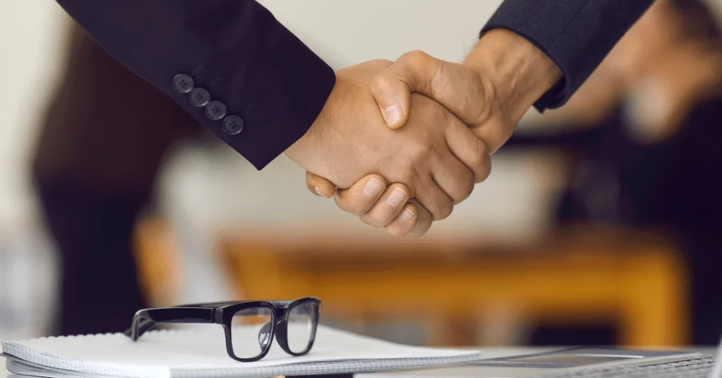 A recruiter and a headhunter giving each other a hand