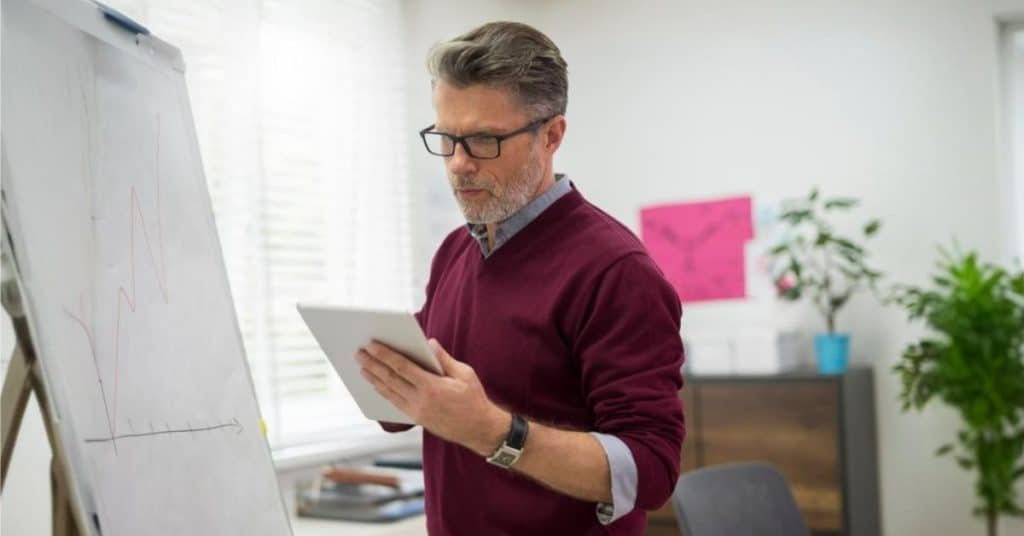 CTO revisando gráficos en una tablet mientras planifica la estrategia tecnológica de la empresa