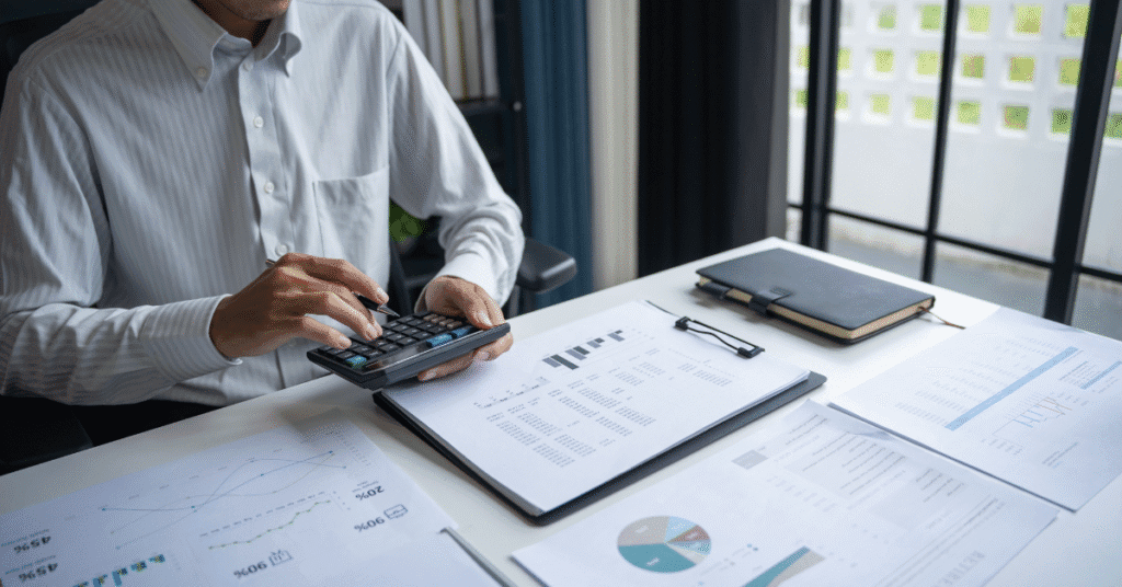 Persona analizando gráficos financieros y datos de cumplimiento laboral en oficina, estrategia corporativa con Kilpatrick